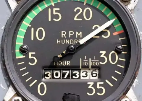 A tachometer with an hour meter on its face