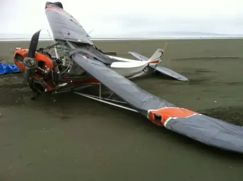 An airplane wreck lying on a sandy beach