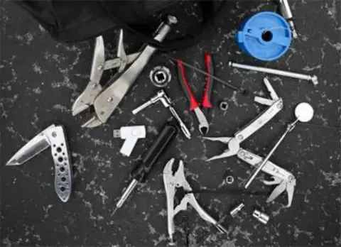 A small set of hand tools laid out on a dark surface