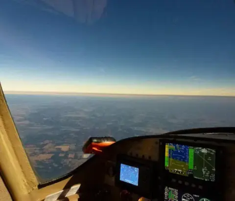 Cockpit view of the horizon at dusk with the instrument panel lit
