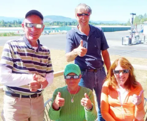 Four people giving a thumbs up on the ramp