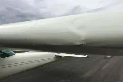 A dented section of a white airplane wing