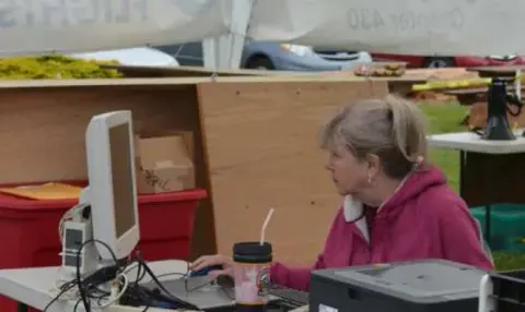 A woman working at a laptop at a Young Eagles registration table