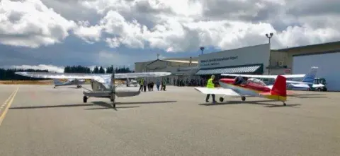 Airplanes parked on the ramp under a cloudy sky