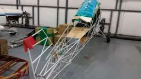 A steel tube fuselage frame under construction in a hangar