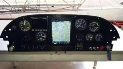 An instrument panel with a glass display and round gauges