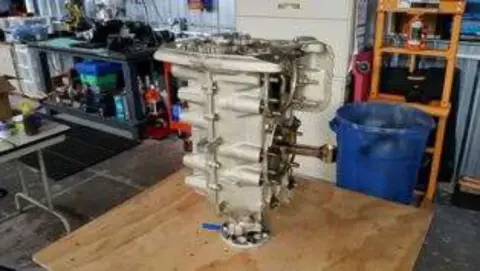 A steel engine mount on a workbench