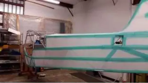 The fabric-covered fuselage painted with green stripes