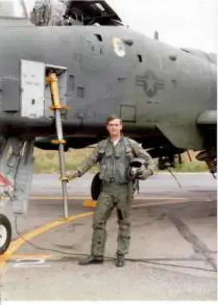A man standing in front of a military jet