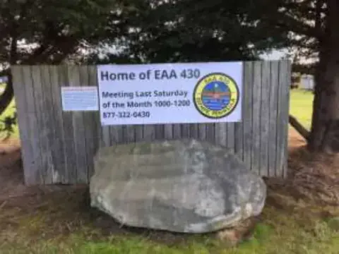 A sign reading Home of EAA 430 on a boulder