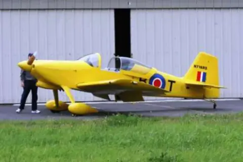 A yellow single-seat airplane with roundel markings on the grass