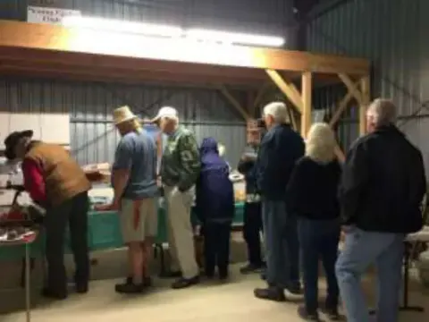 Members lining up for food in a hangar