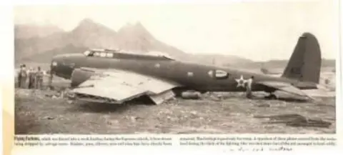 A black and white photo of a World War II fighter on the ground