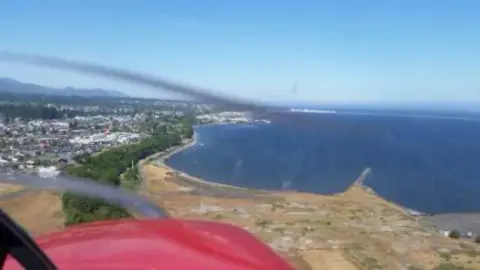 A view across the water toward a waterfront from the cockpit