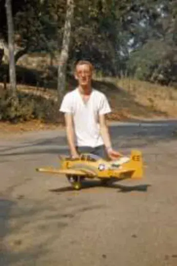 A man holding a small model airplane outdoors