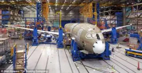 A factory floor with airliner fuselage sections being assembled