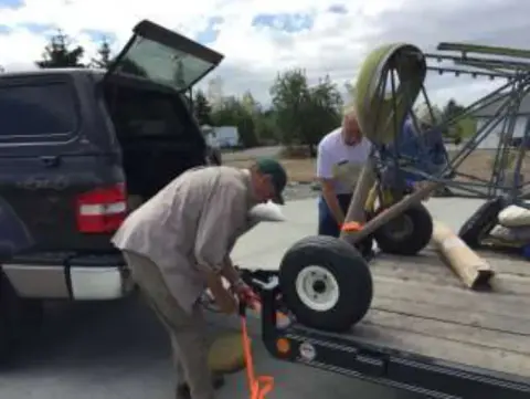 Loading parts of the Smith Mini Biplane from the back of a pickup truck