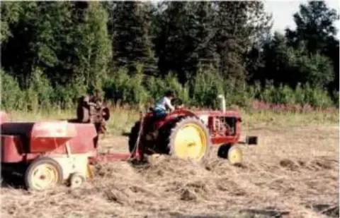 A man on a red tractor working a field
