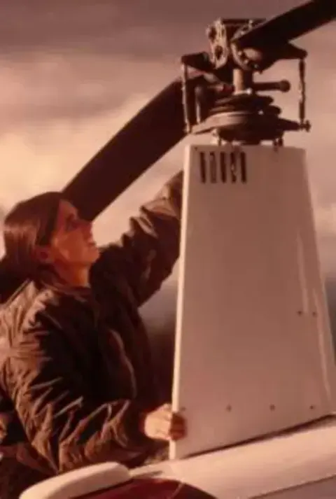 Doing a pre-flight on her helicopter