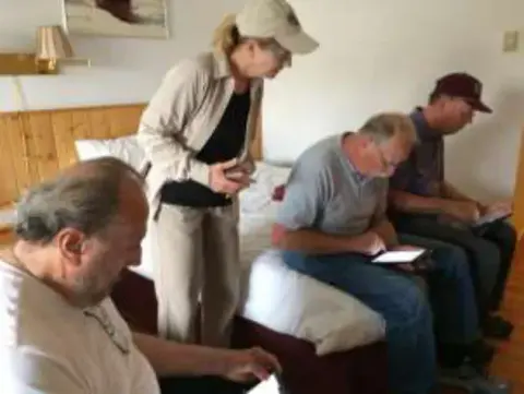 Members looking at photos and notes during the presentation