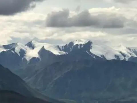 Snowy mountain peaks under clouds