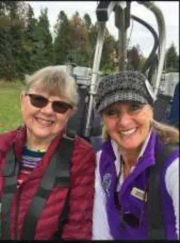 A woman in sunglasses and a woman in a purple vest in a balloon basket