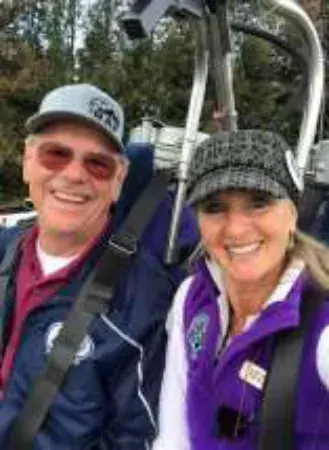A man in a cap and a woman in a purple vest in a balloon basket