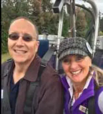 A smiling man and woman taking a selfie beside an airplane