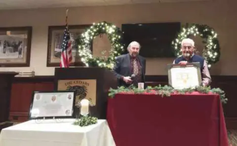 Two people at a decorated table during a holiday party