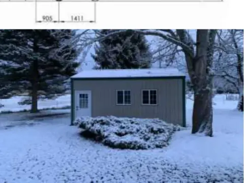 A small shed with a snowy yard
