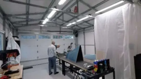 A clean workshop with workbenches and bright lights