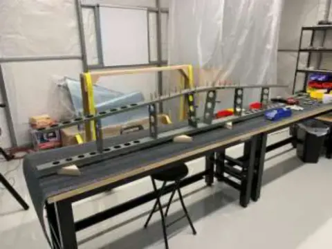 A shop with long benches and parts laid out