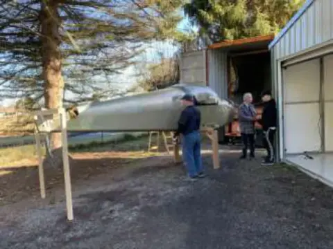 Men moving a shipping crate into a garage