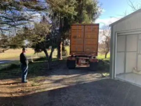 A man next to a delivery truck by the shop