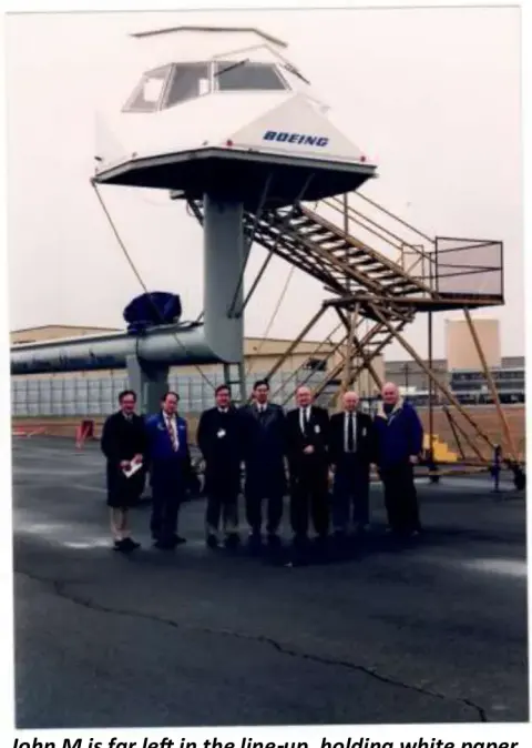 People gathered at the base of an airport control tower