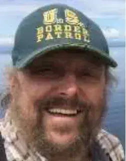 A smiling bearded man in a Border Patrol cap