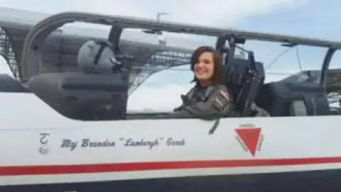 A young woman in the rear seat of a jet trainer