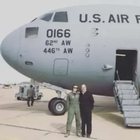 Two people in flight suits by a U.S. Air Force C-17
