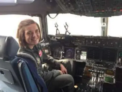 A young woman in the pilot seat of a large jet