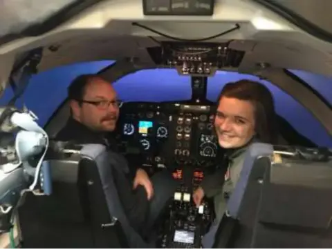 Two people sitting in the cockpit of a jet