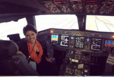 A woman at the controls of an airliner flight deck
