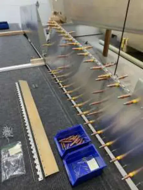 Wing ribs held with clamps on a workbench, with a box of parts
