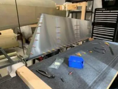 An aircraft wing on a workbench with tools