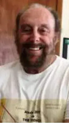 A smiling bearded man indoors