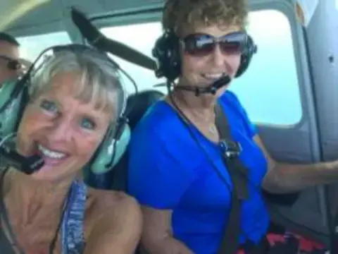 Two women wearing headsets in a cockpit