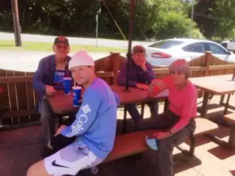 Four members sitting at a picnic table with drinks