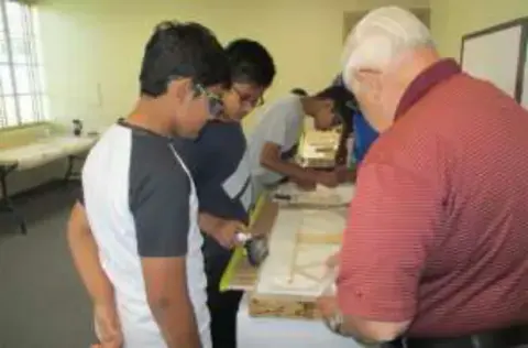 Students building models with an adult helper