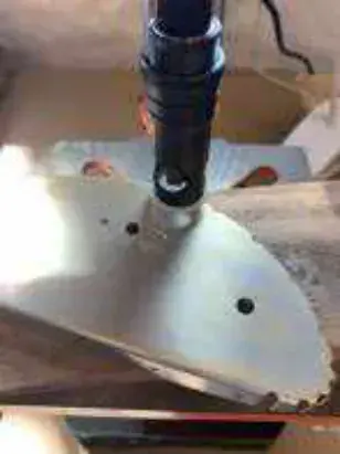 A drill bit over a metal aircraft part