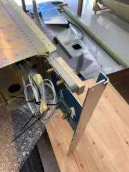 A metal aircraft part clamped on a workbench