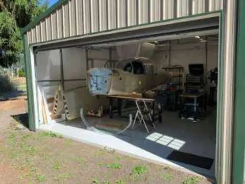 An airplane under construction in an open garage